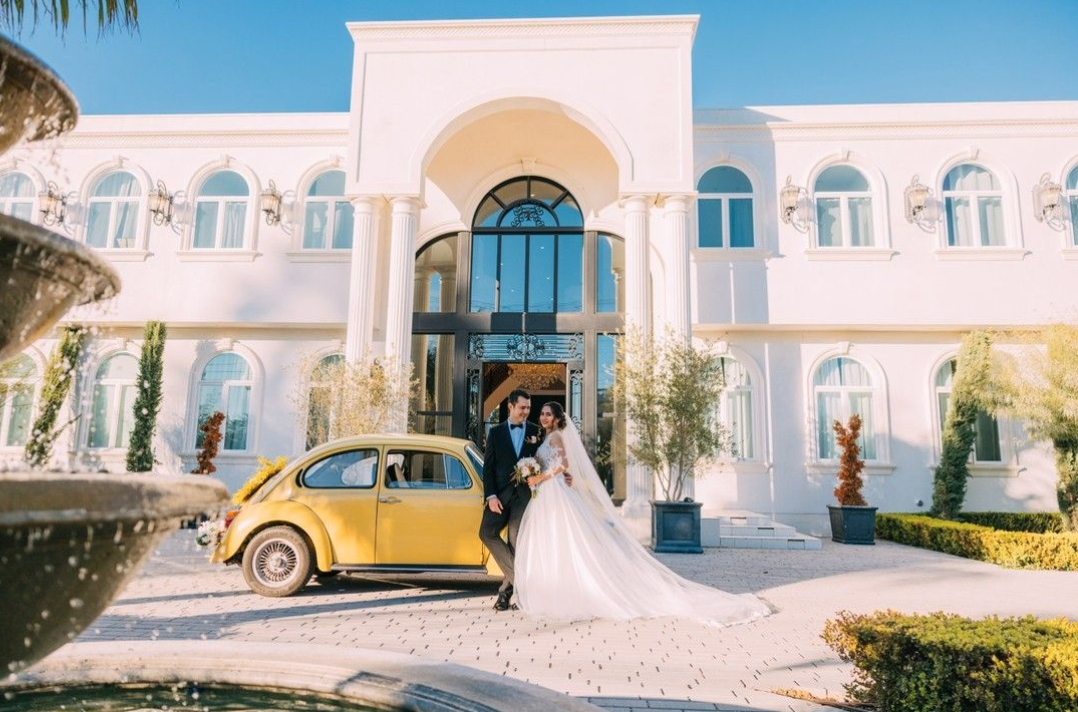 A newly wed couple in front of their ceremony venue