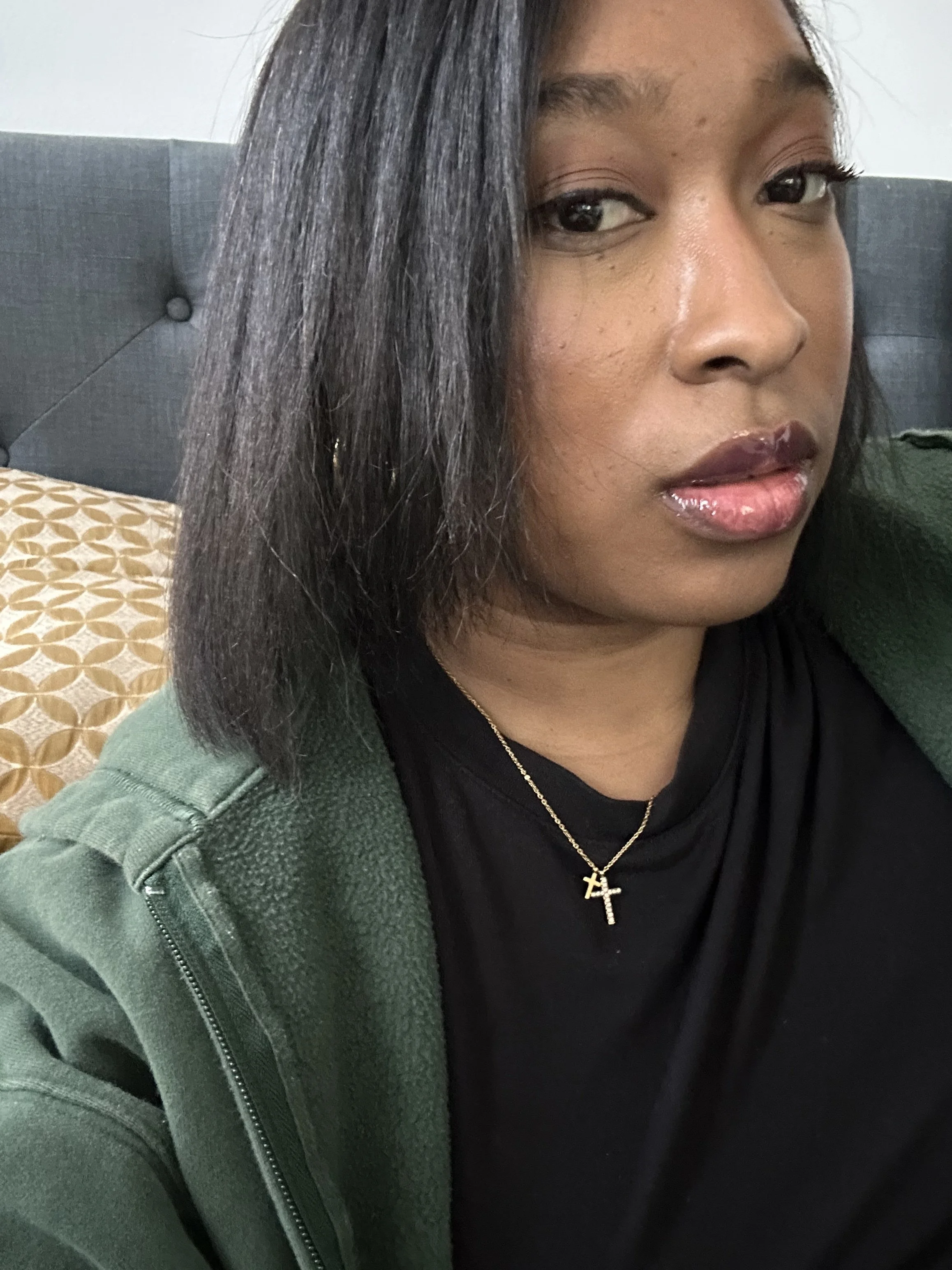 Side profile view of a woman showcasing a sleek, bone-straight professional silk press on her dark hair, styled into a sharp, shoulder-length blunt bob with a precise side part.