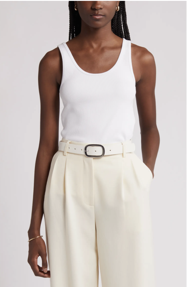 Close-up of a white ribbed scoop-neck cotton tank top styled with cream trousers.