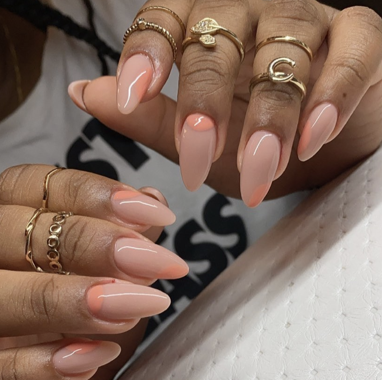 Long almond-shaped nails with a smooth peach nude base and a soft neon peach French tip, showcasing minimalist and cute June nail ideas.