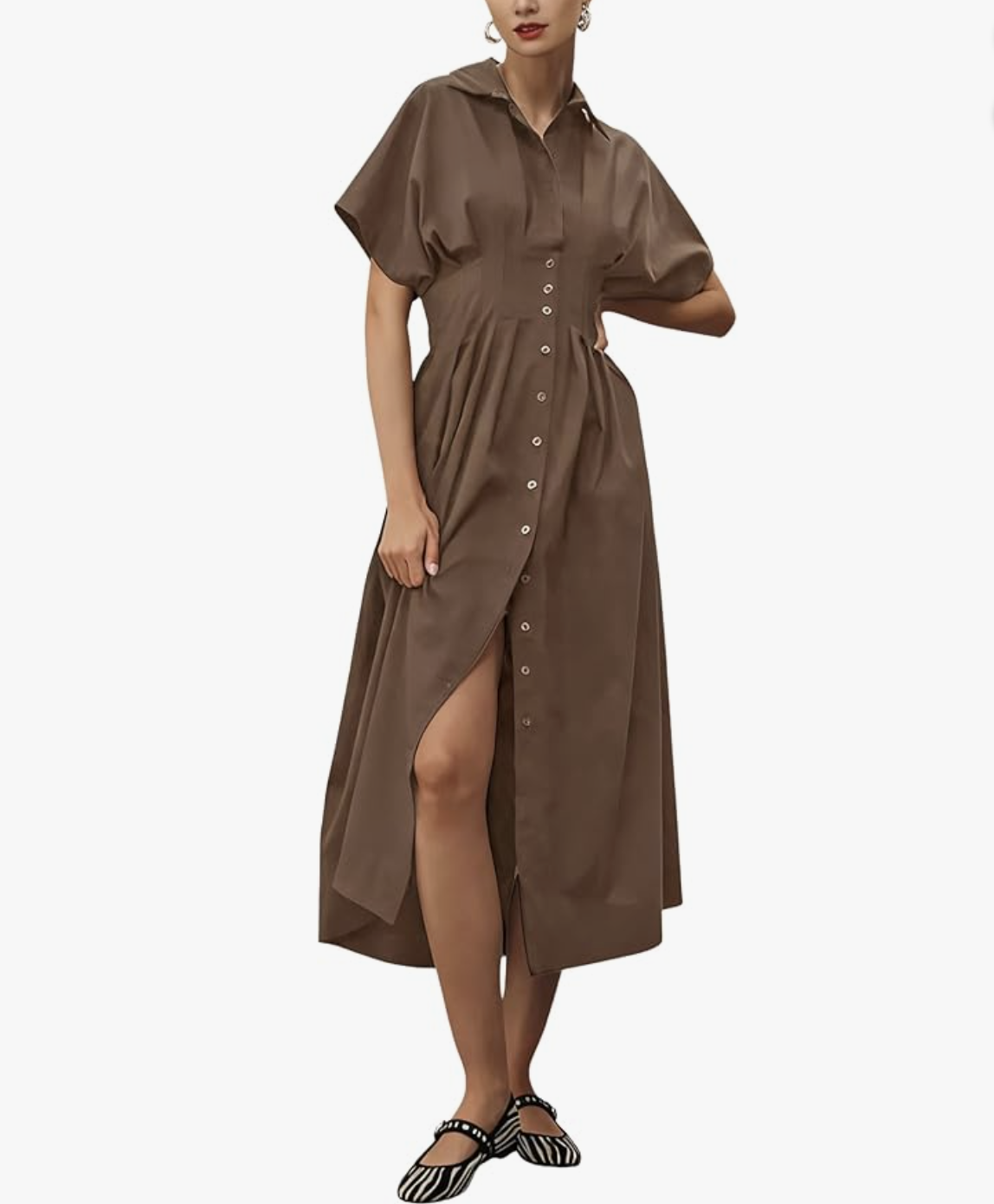 A woman wearing a short-sleeve, brown linen-blend maxi shirt dress with a button-front closure, pointed collar, and structured waist detailing, paired with zebra-print mary jane flats.