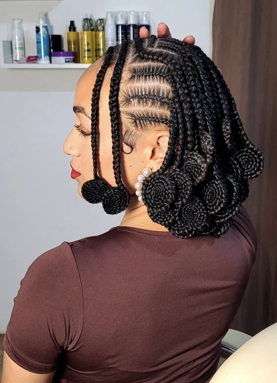 Koroba braids finished with sculptural rolled ends in a short rounded silhouette.