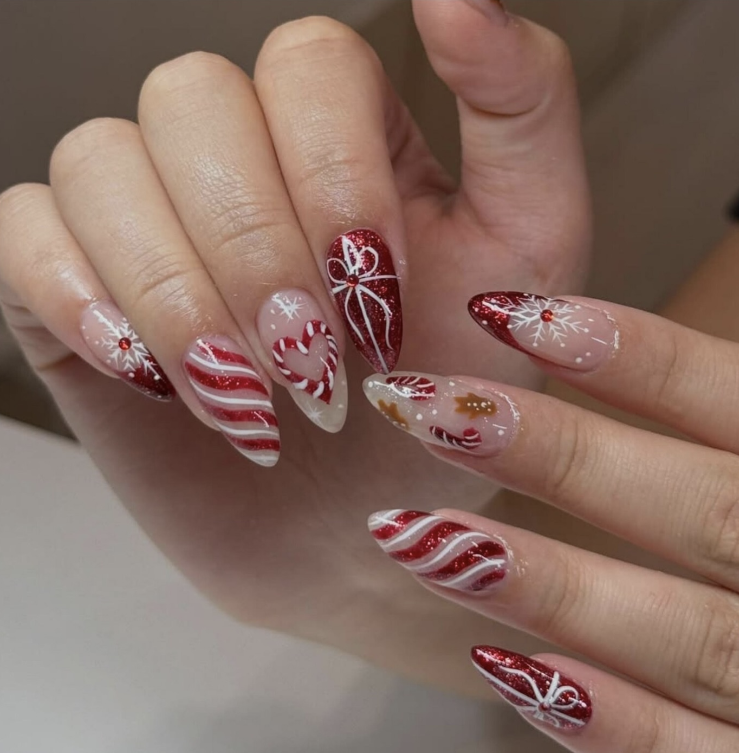 Two striped candy canes forming a heart on a sheer Christmas manicure