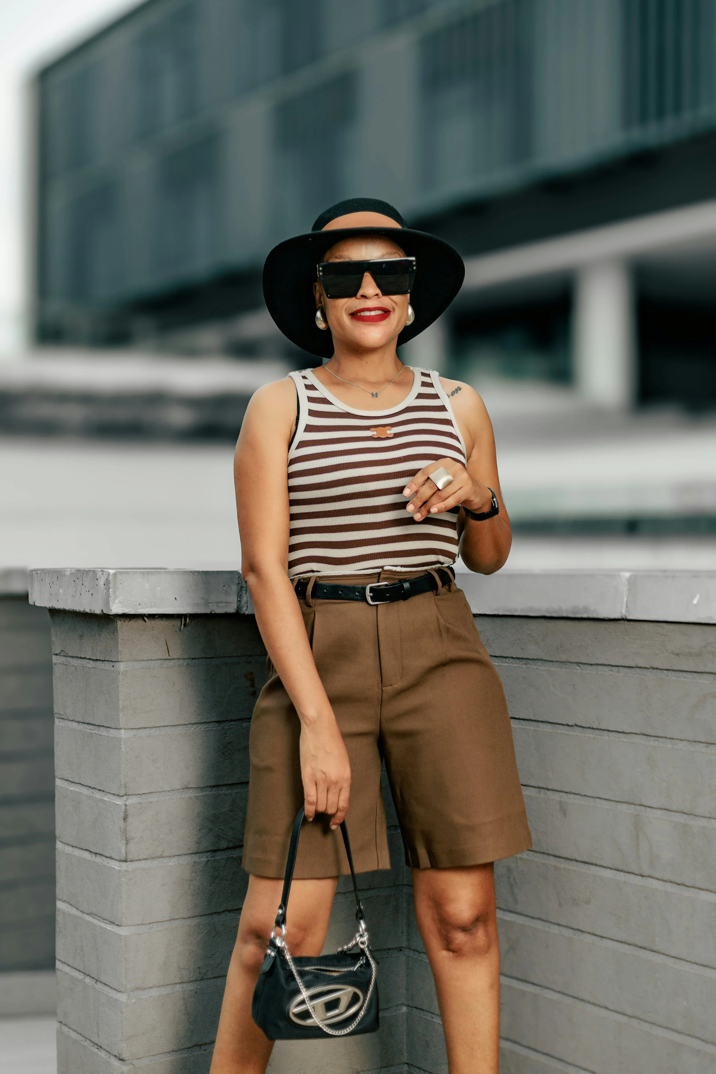 Woman in her 60s wearing a striped tank top and tan tailored shorts from an Amazon spring capsule wardrobe.