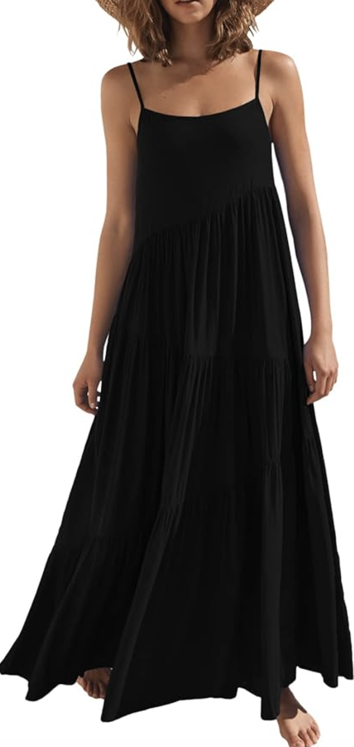 A woman wearing a black flowy spaghetti strap maxi dress, demonstrating what to wear with a spaghetti strap dress for a boho summer look.