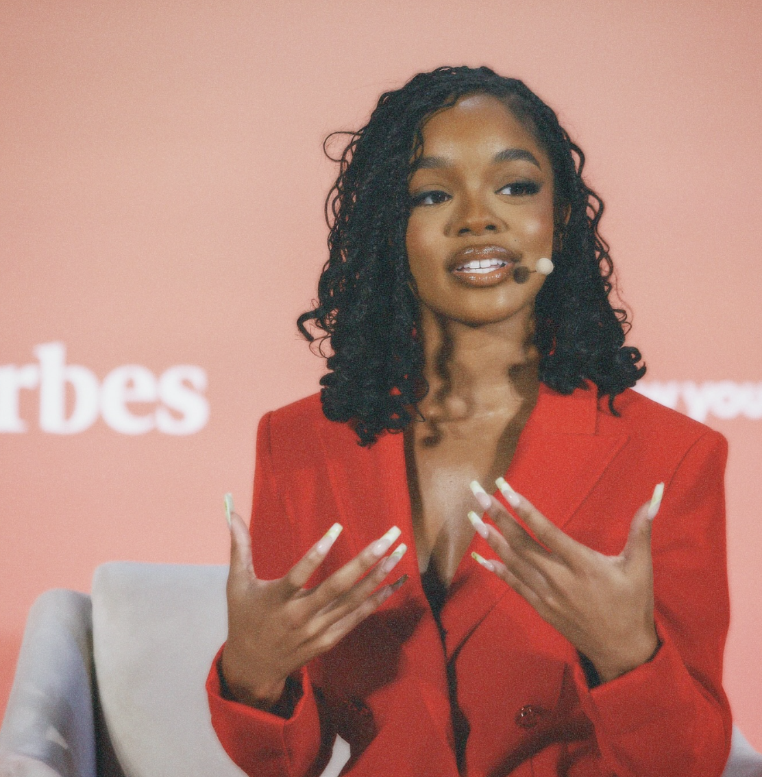 Marsai Martin wearing medium-sized box braids with a deep side part to complement an oval face shape.