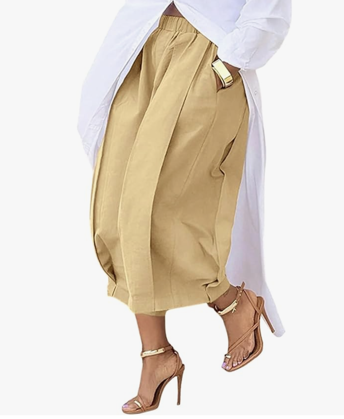 A person wearing voluminous khaki-colored baggy capri pants with pockets, styled with a white button-down shirt and brown heels.