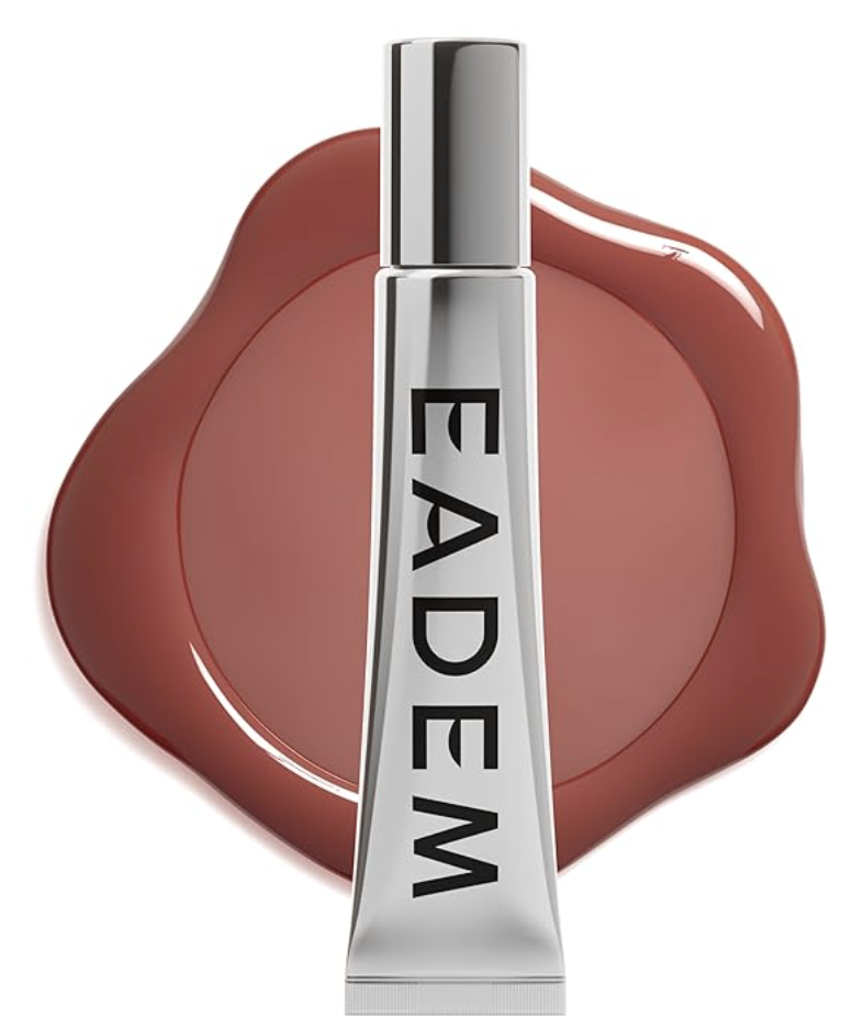 A silver tube of EADEM Le Chouchou Lip Softening Balm positioned vertically against a background of a large, glossy brown lip gloss swatch.