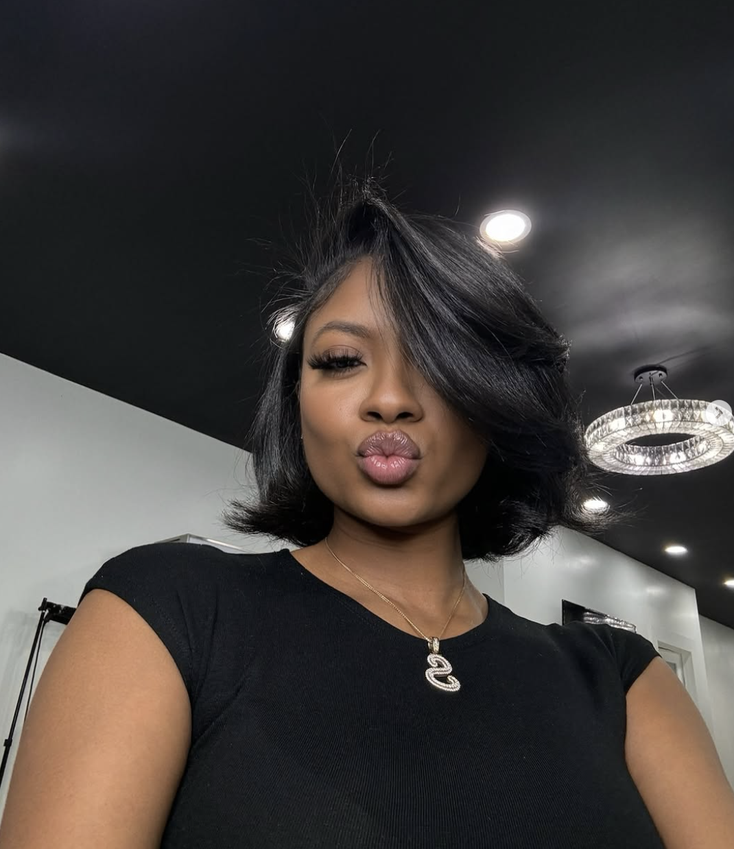 Silk press bob styled with a deep side part and swooped face-framing bangs