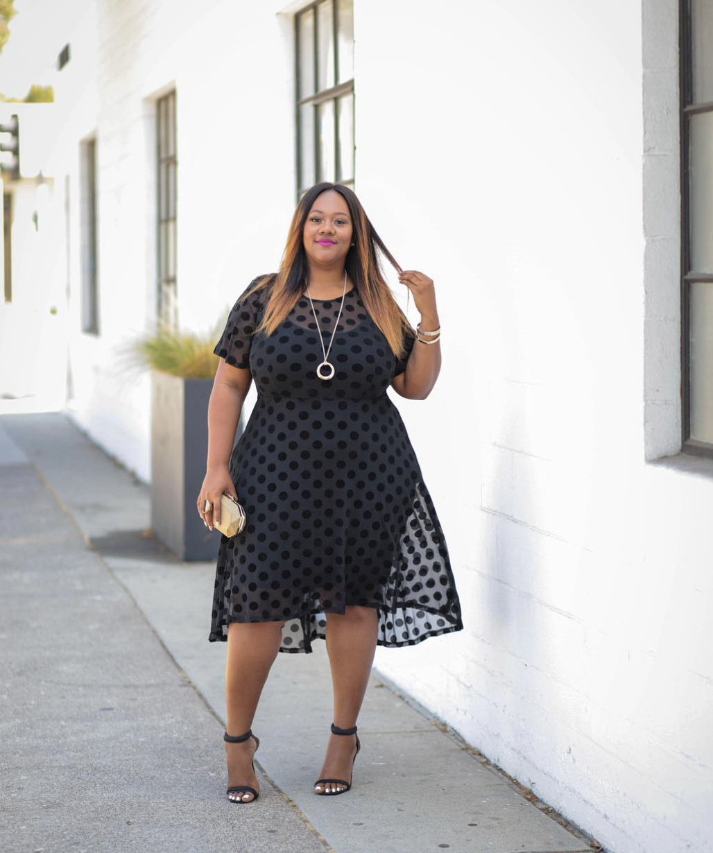 woman in a sheer black polka dot dress layered over a solid underlayer — summer polka dot outfit idea