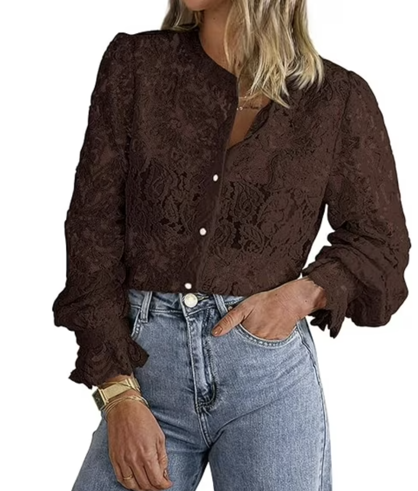 A woman wearing a dark brown long-sleeve lace button-up blouse with intricate floral patterns, tucked into classic blue jeans.