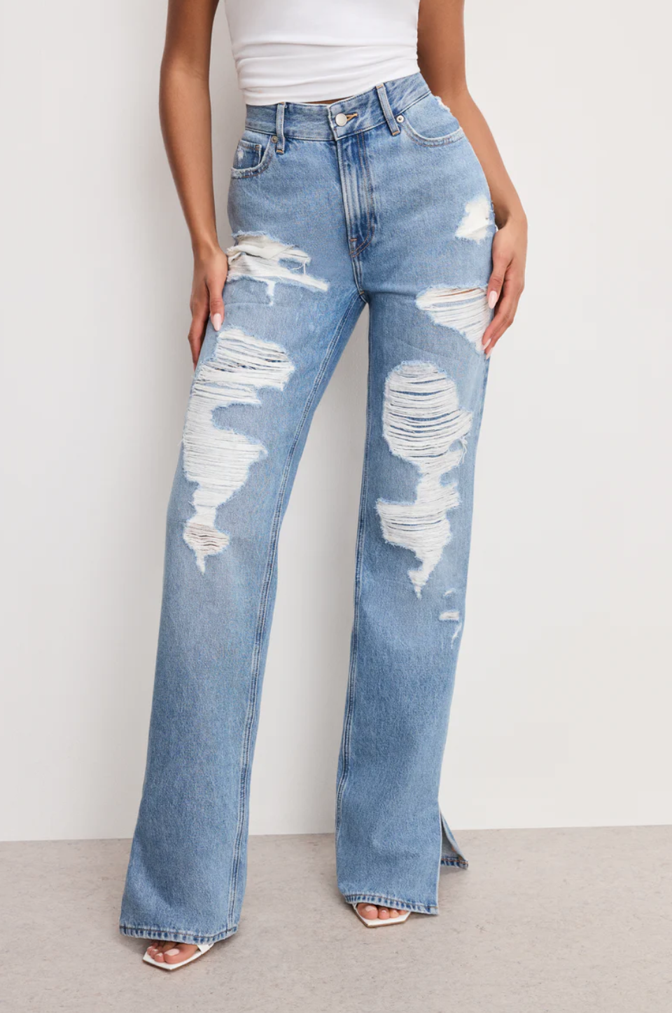 Good American The Khloe Long Jeans in a light wash with distressed knee details and a wide-leg opening, designed for a full-length fit on tall women.