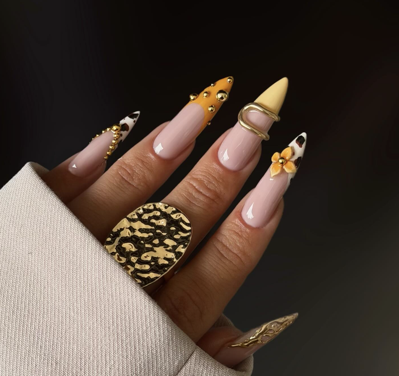 Long light pink coffin nails featuring a 3D butter yellow flower accent and intricate gold metallic details, a perfect look for cute June nail ideas.