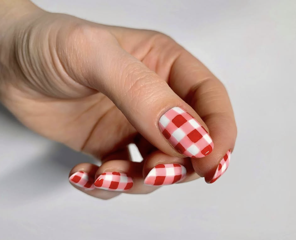 Almond-shaped nails featuring a classic red and white gingham checkered pattern.