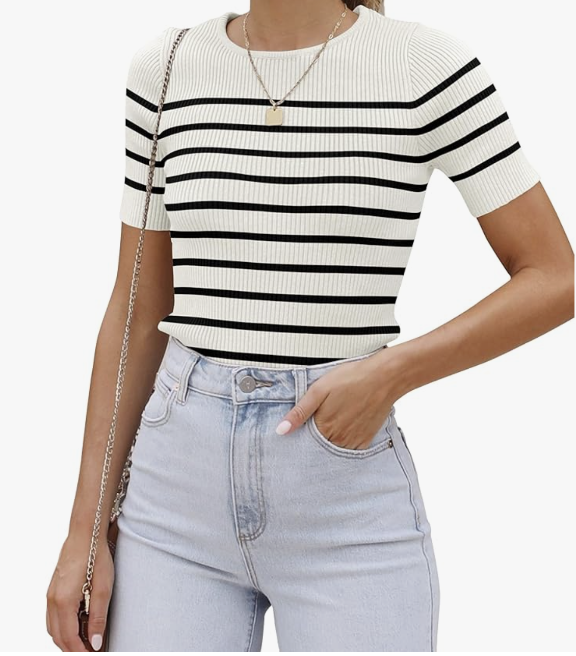 A woman wearing a white and black striped short-sleeve crewneck t-shirt tucked into light-wash high-waisted jeans.