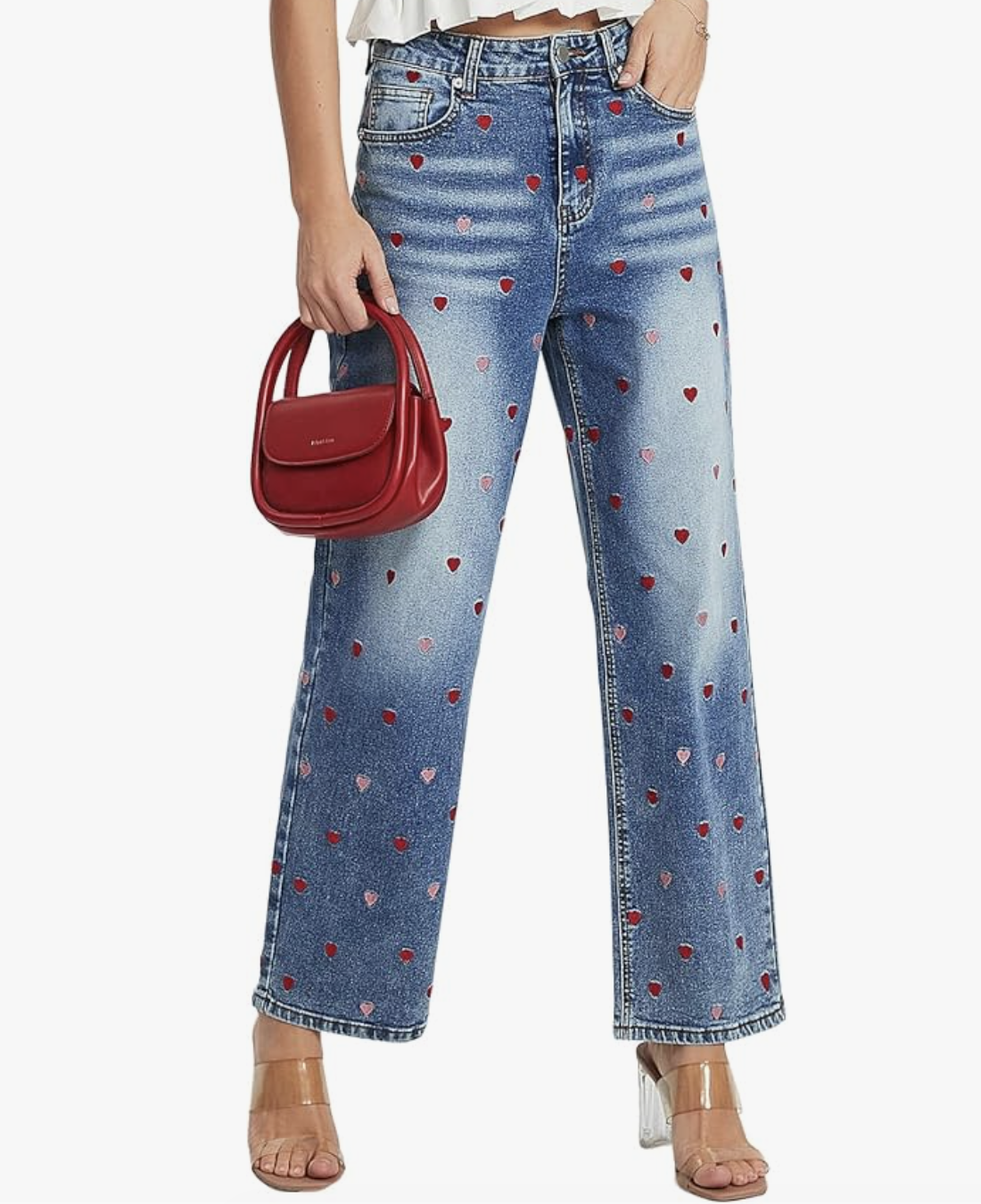 A close-up of a woman wearing light-wash wide-leg jeans featuring small red heart embellishments scattered across the denim, styled for a playful yet sophisticated spring look for women in their 50s.