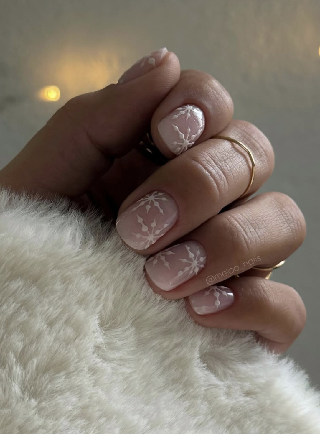 Short winter nails with delicate white snowflake nail art
