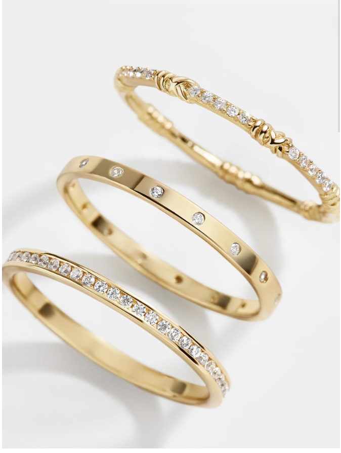 A stack of three Baublebar Maddie 18K Gold Rings, featuring slim gold bands with inset crystals.