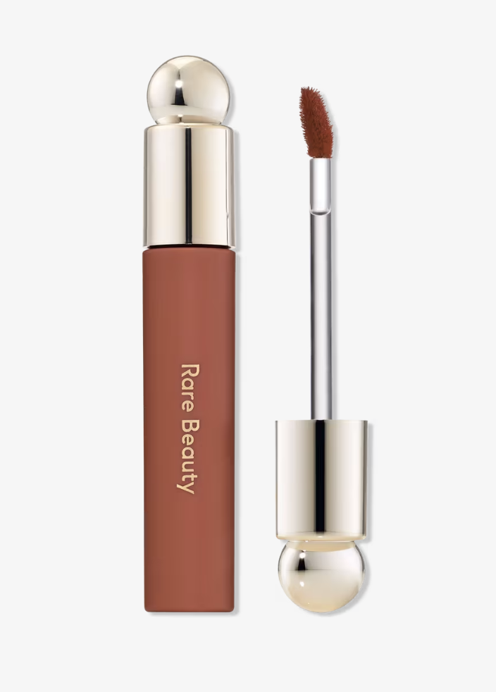 A close-up of Rare Beauty Soft Pinch Tinted Lip Oil next to its applicator wand.