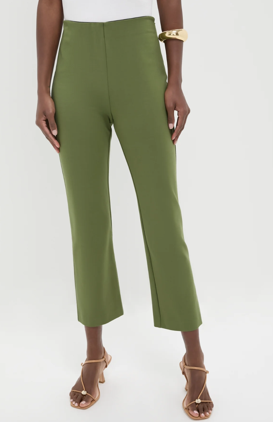 Close-up of olive green cropped tailored trousers paired with tan strappy heeled sandals.
