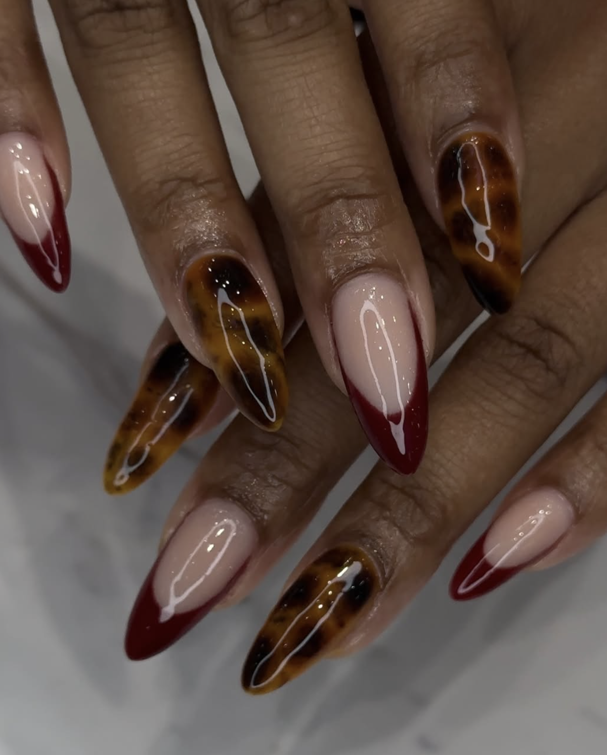 Red tip nail design with tortoiseshell accent nail