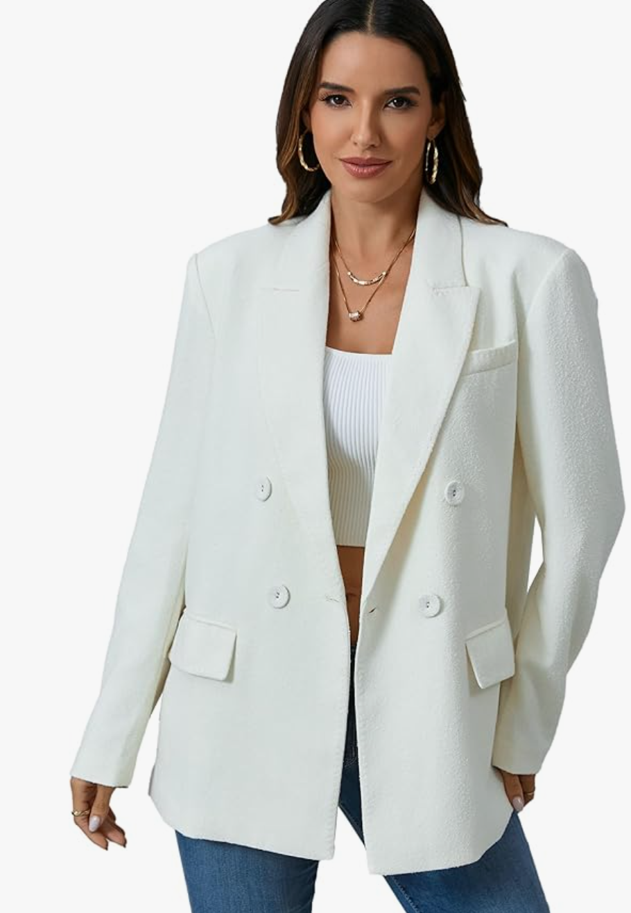A woman wearing a crisp white Oversized Double-Breasted Suit Blazer Jacket over a white top and blue jeans, showcasing a modern and professional layered office look.