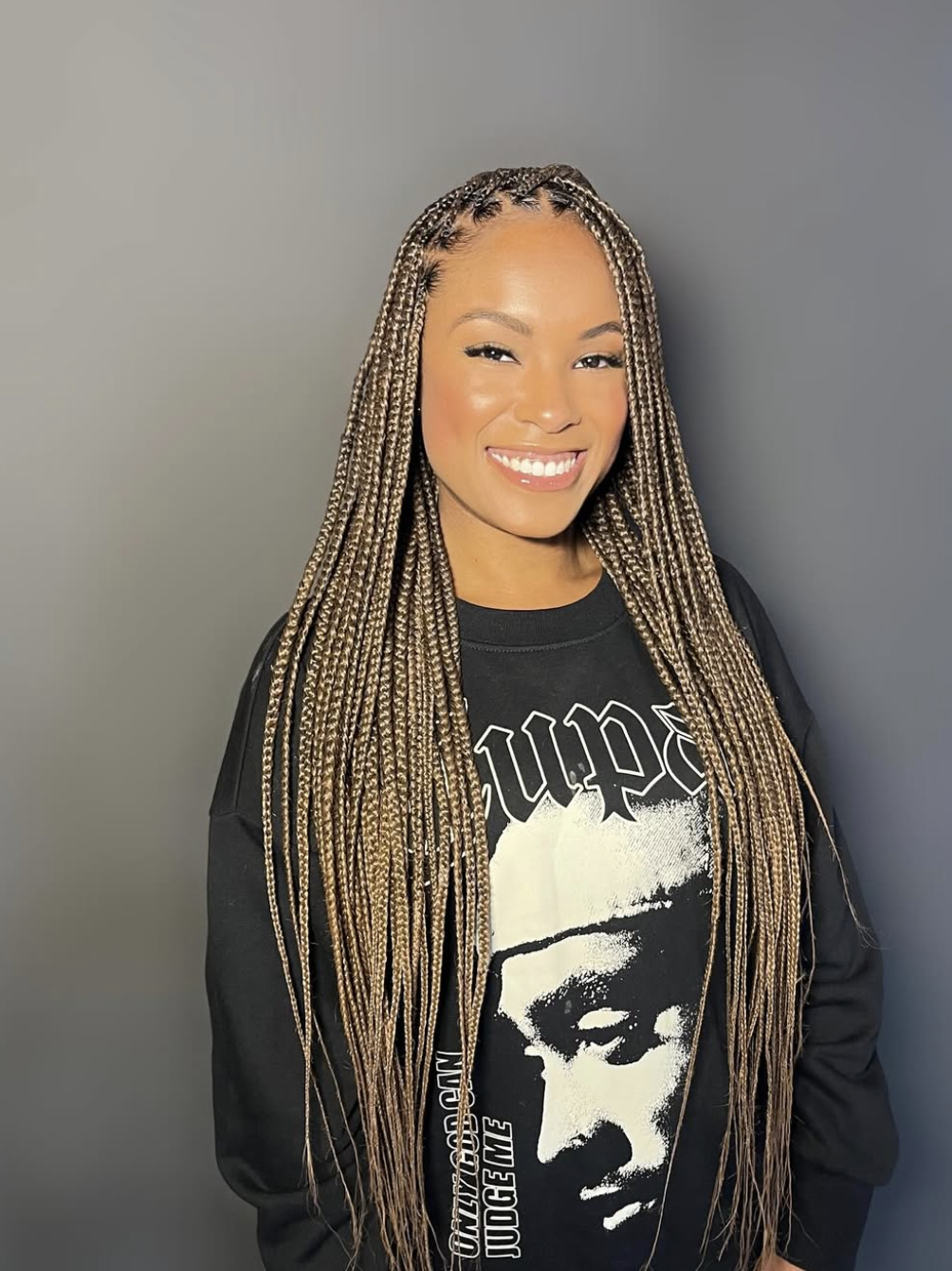 Long individual braids worn down with a clean center part and smooth finish.