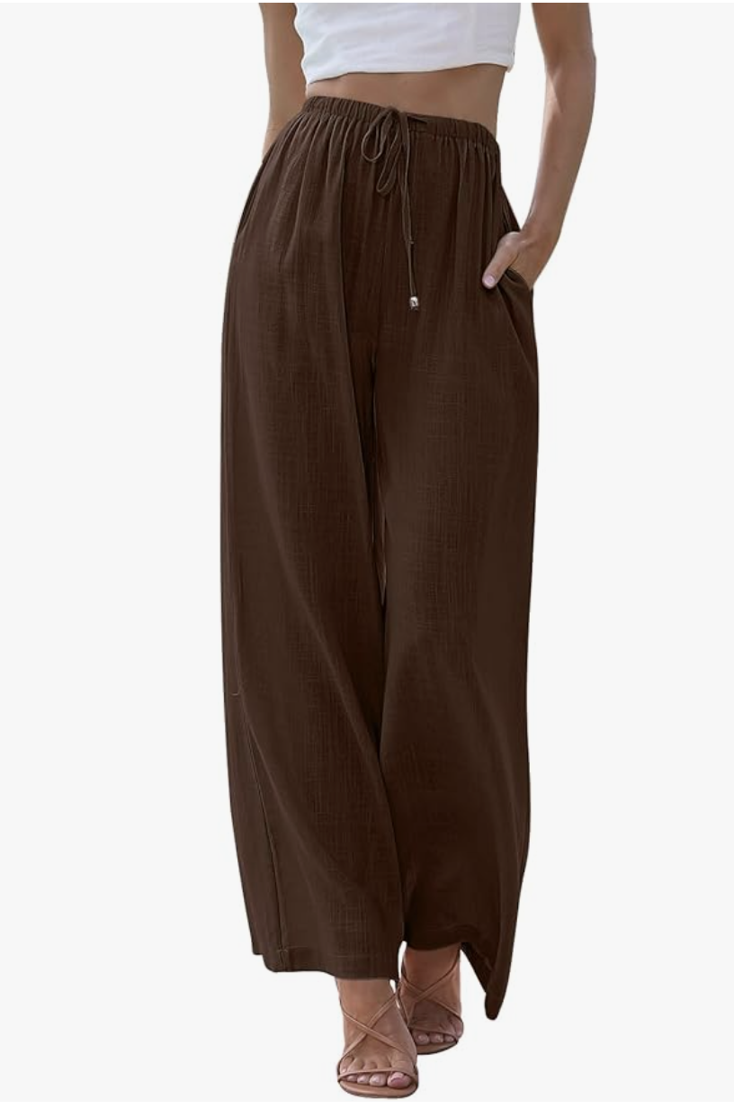 A woman wearing dark brown wide-leg linen palazzo pants with a drawstring waist and side pockets, styled for a comfortable and breathable spring outfit for women in their 60s.