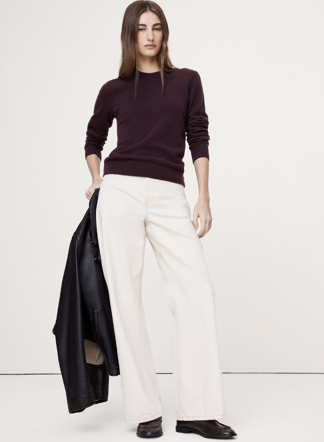 A professional work outfit featuring high-waisted white wide-leg trousers and a chocolate brown cashmere sweater, perfect for styling with minimalist sneakers.