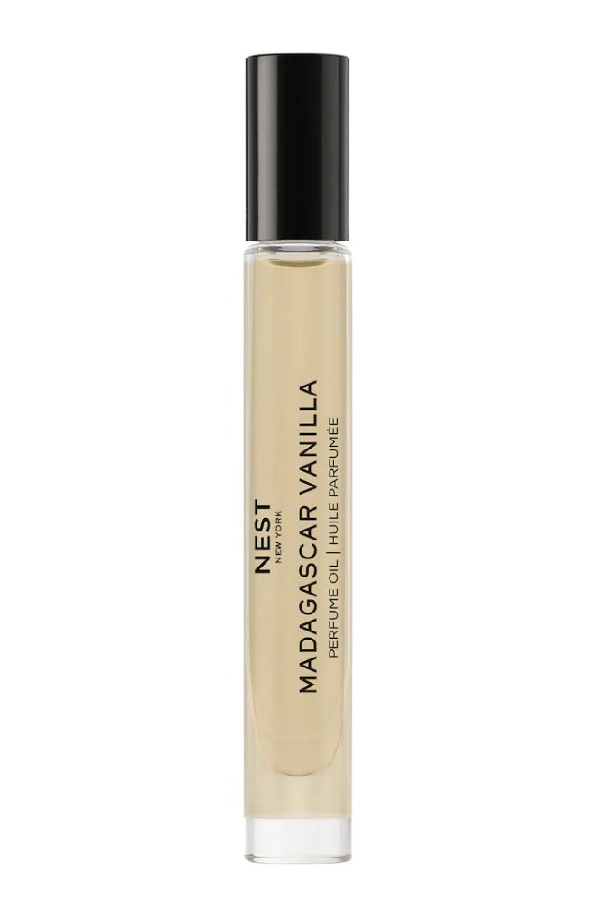 A slim, vertical glass rollerball bottle of NEST New York Madagascar Vanilla Perfume Oil with a black cap and a beige label featuring elegant black typography.