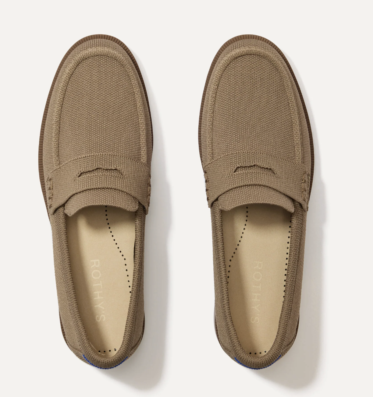 Top-down view of Rothy's The Penny Loafer in Portobello, a washable earthy brown loafer with a plush beige footbed, styled for a polished fashion editor-inspired outfit.
