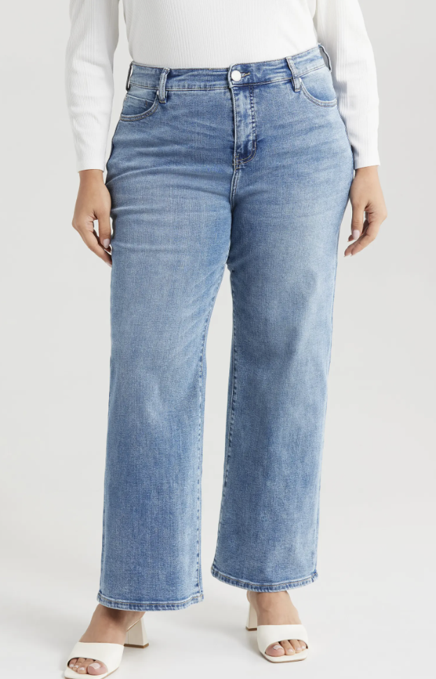 Woman wearing Liverpool Los Angeles Stride High Waist Wide Leg Jeans in a light blue wash, styled with white block heel sandals.