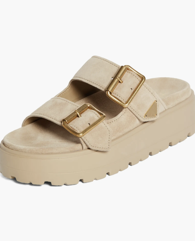 A side view of a beige padded nappa leather platform slide sandal with two wide buckled straps and a chunky lug sole.