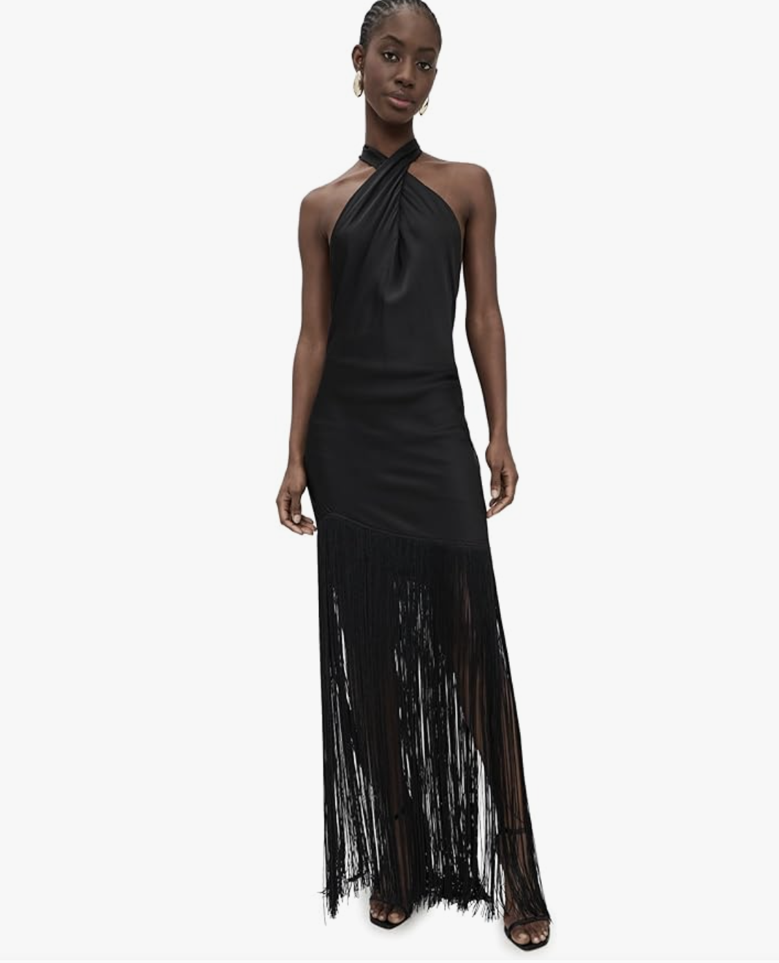 A woman wearing a black halter-neck maxi dress with long, dense fringe tiers that create a floor-length silhouette.