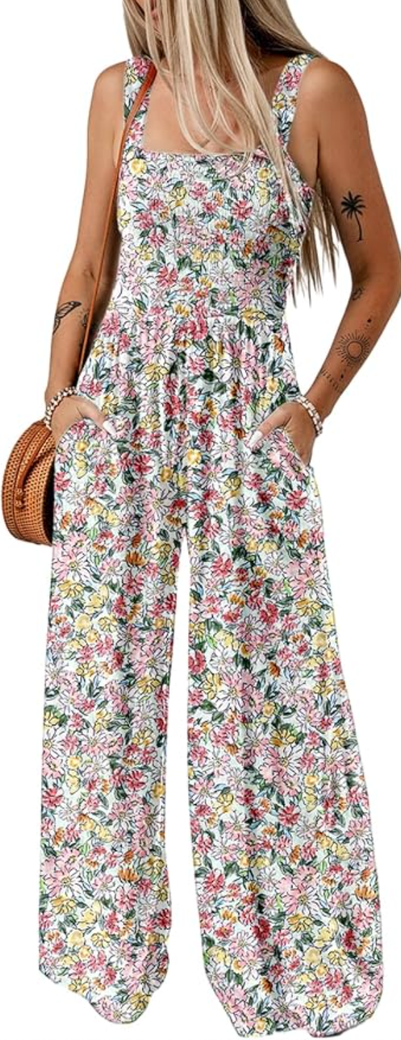 A woman wearing a colorful floral print wide-leg jumpsuit with adjustable spaghetti straps and a flowy silhouette.