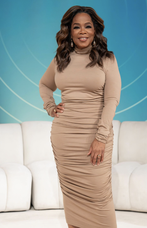 Oprah Winfrey wearing a muted, warm-neutral tan dress, illustrating how rich, earthy tones and deep warmth harmonize with the Deep Autumn season.