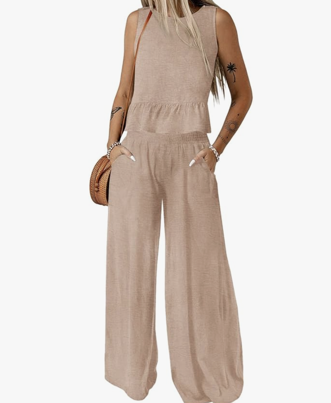 A product view of a woman wearing a relaxed tan linen matching set featuring a sleeveless high-neck tank top and matching wide-leg trousers, styled with a small woven straw shoulder bag.