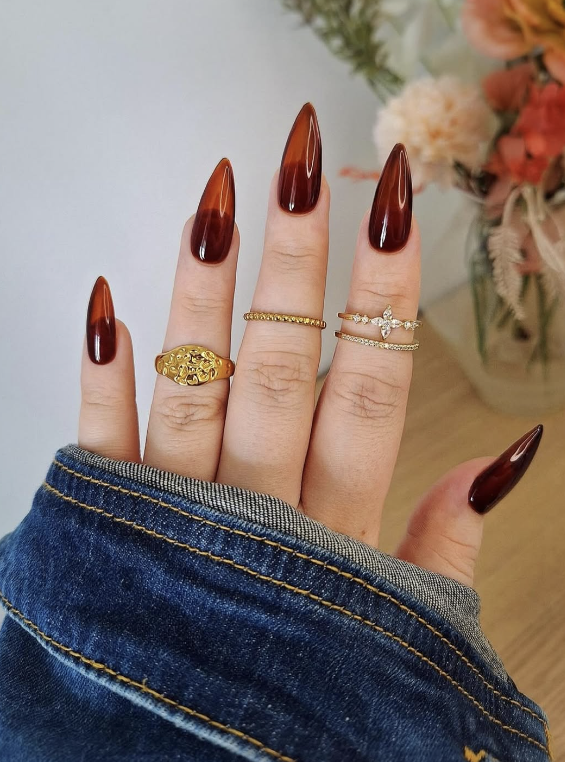 heer caramel jelly nails manicure photographed close up on hands. Adjust to accurately describe the finished image.
