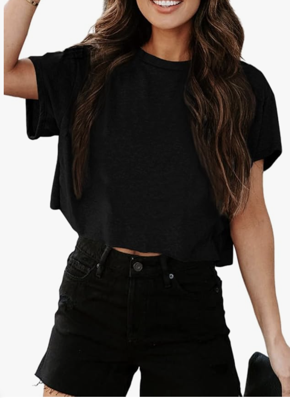 A woman wearing a black short-sleeve crewneck cropped t-shirt paired with high-waisted black denim shorts.