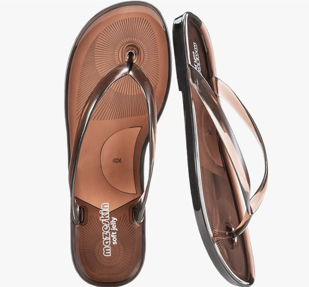 A product view of a pair of translucent, dark brown thong-style jelly sandals with a glossy strap and comfortable flat sole, perfect for a casual summer linen outfit.