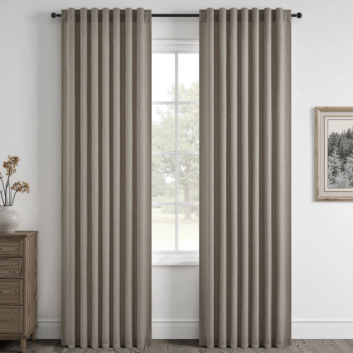Taupe grommet-top curtains mounted close to the ceiling next to a large window, skimming the floor beside a wooden chest of drawers.