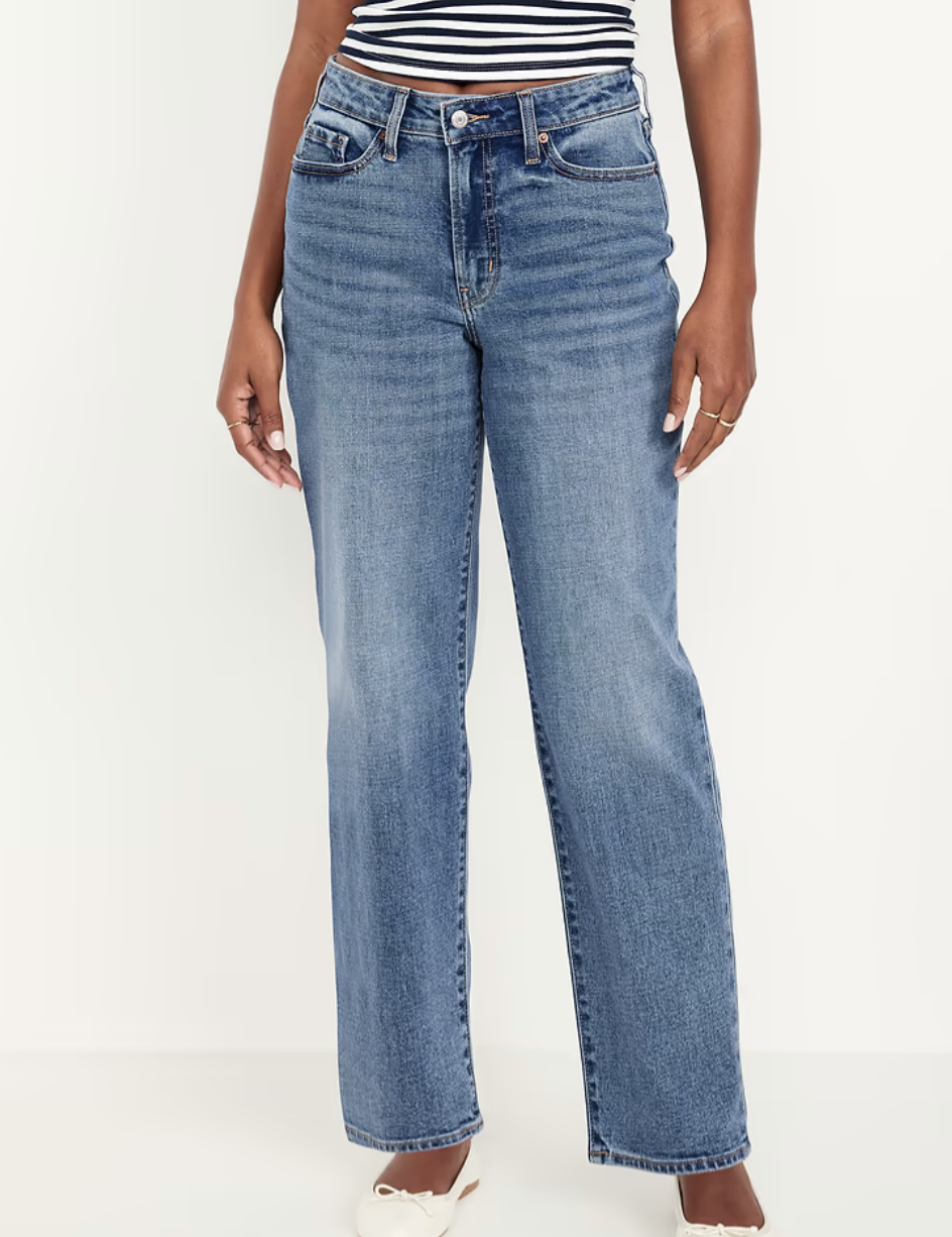 Front view of high-waisted medium wash straight-leg loose jeans, styled with a striped top and white flat shoes.
