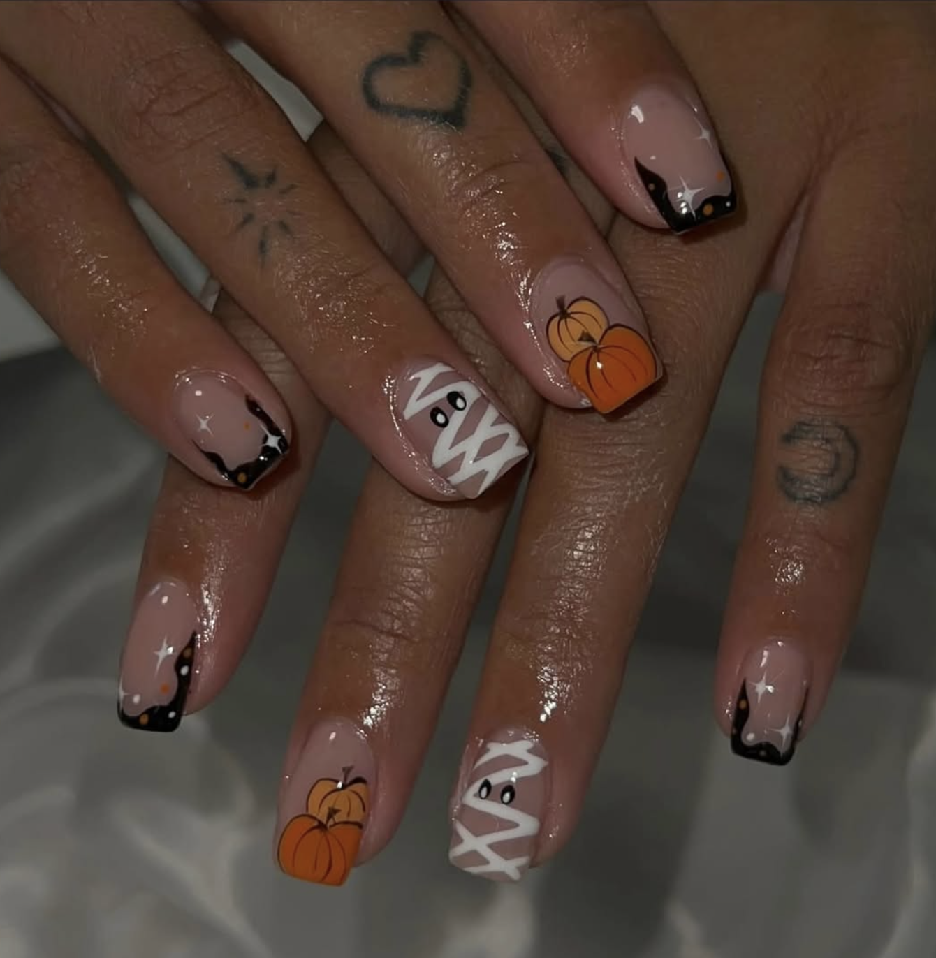 Neutral fall manicure featuring friendly ghosts and small pumpkins