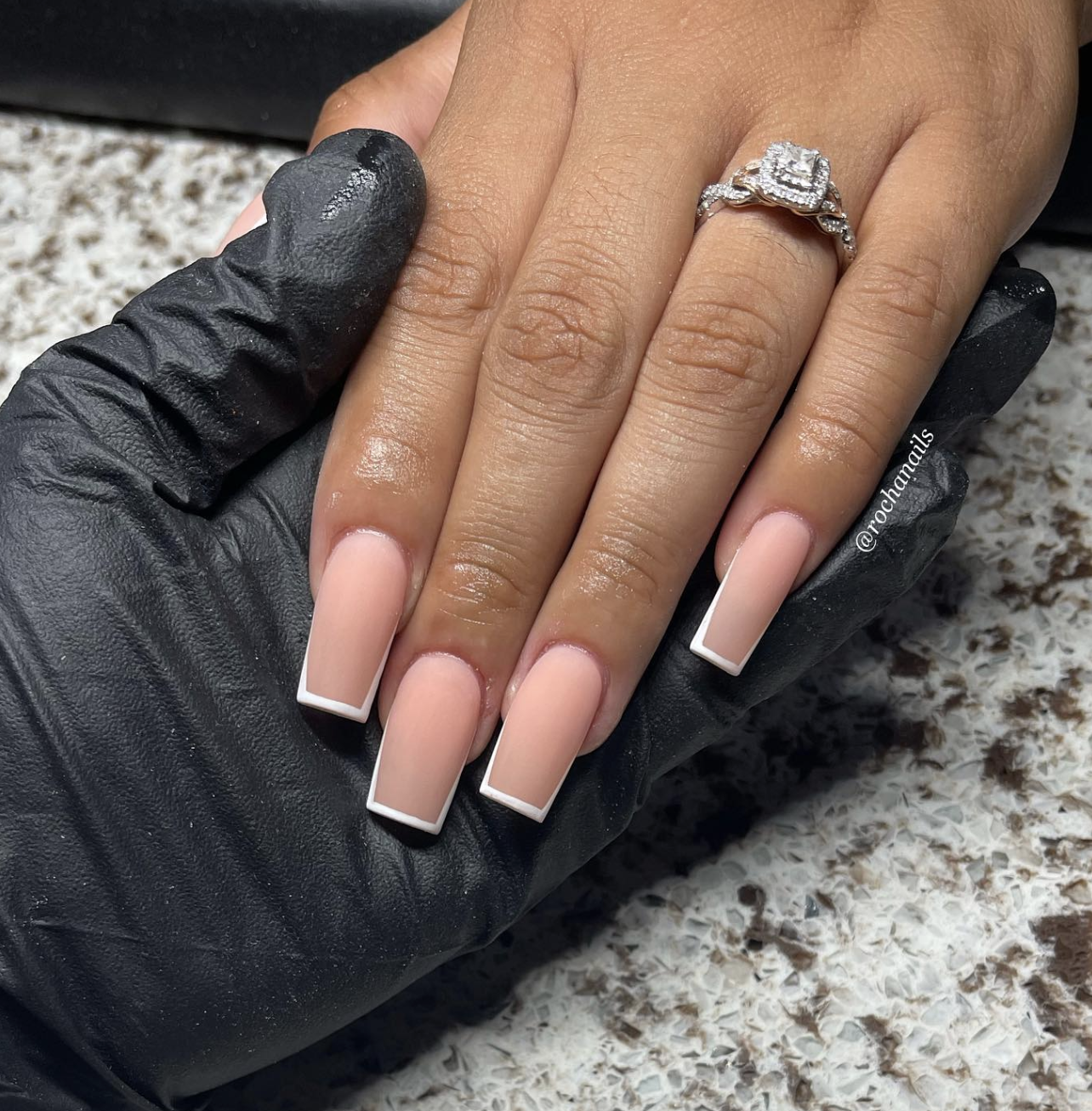 Close-up of short square nails featuring a micro French manicure with a velvet-matte nude base and thin glossy white tips.