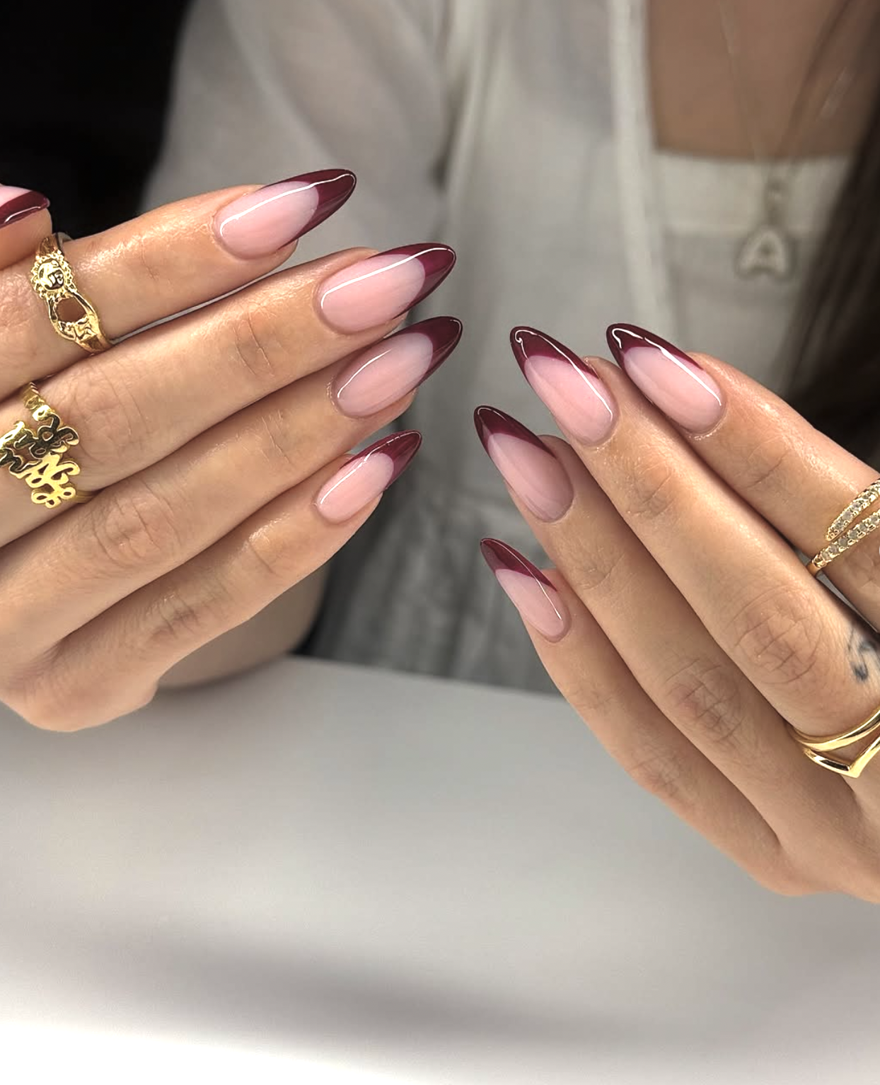 Burgundy french tip manicure on almond-shaped nails