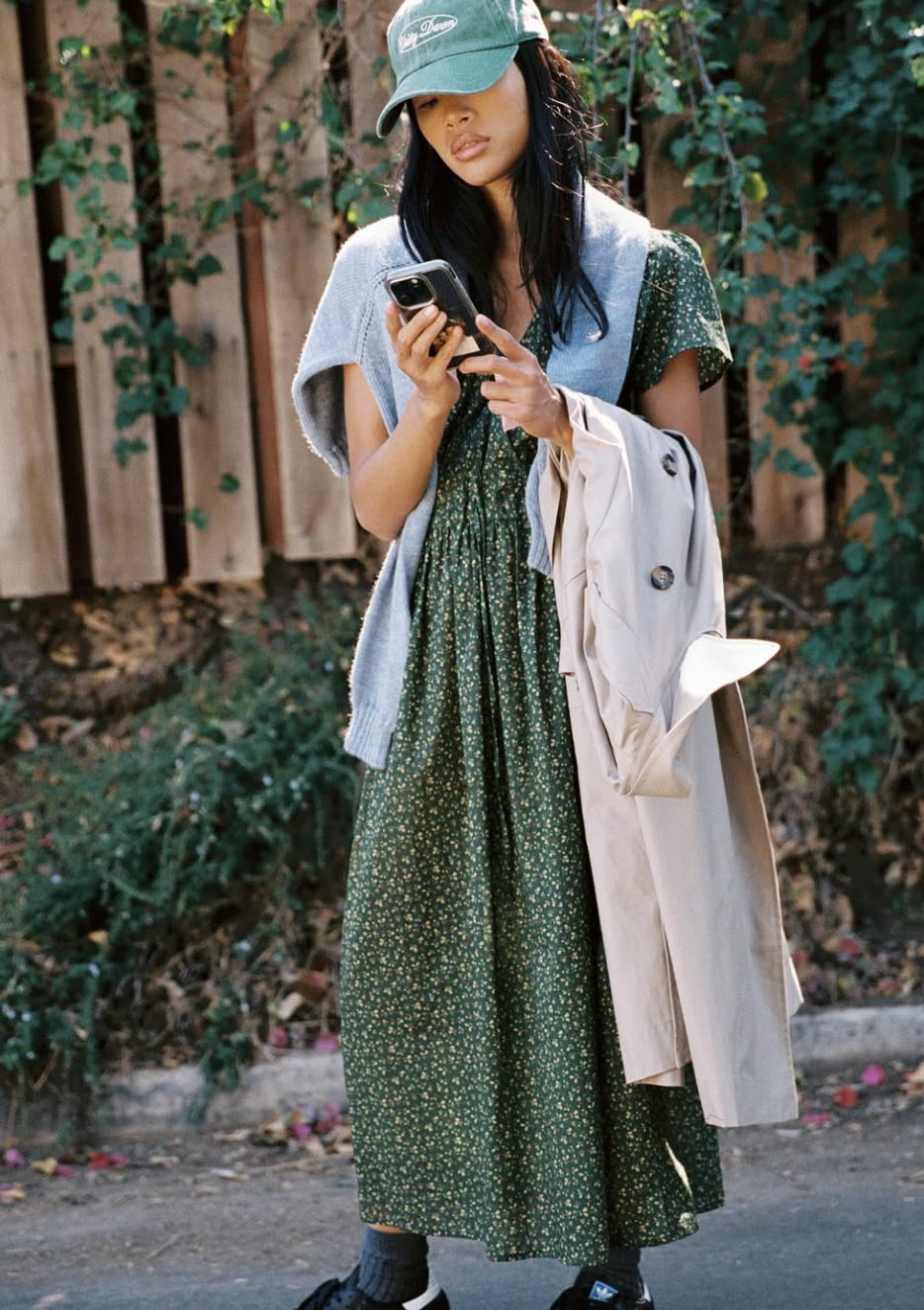 A woman wearing a green tiered cotton maxi dress with simple tan leather slide sandals.