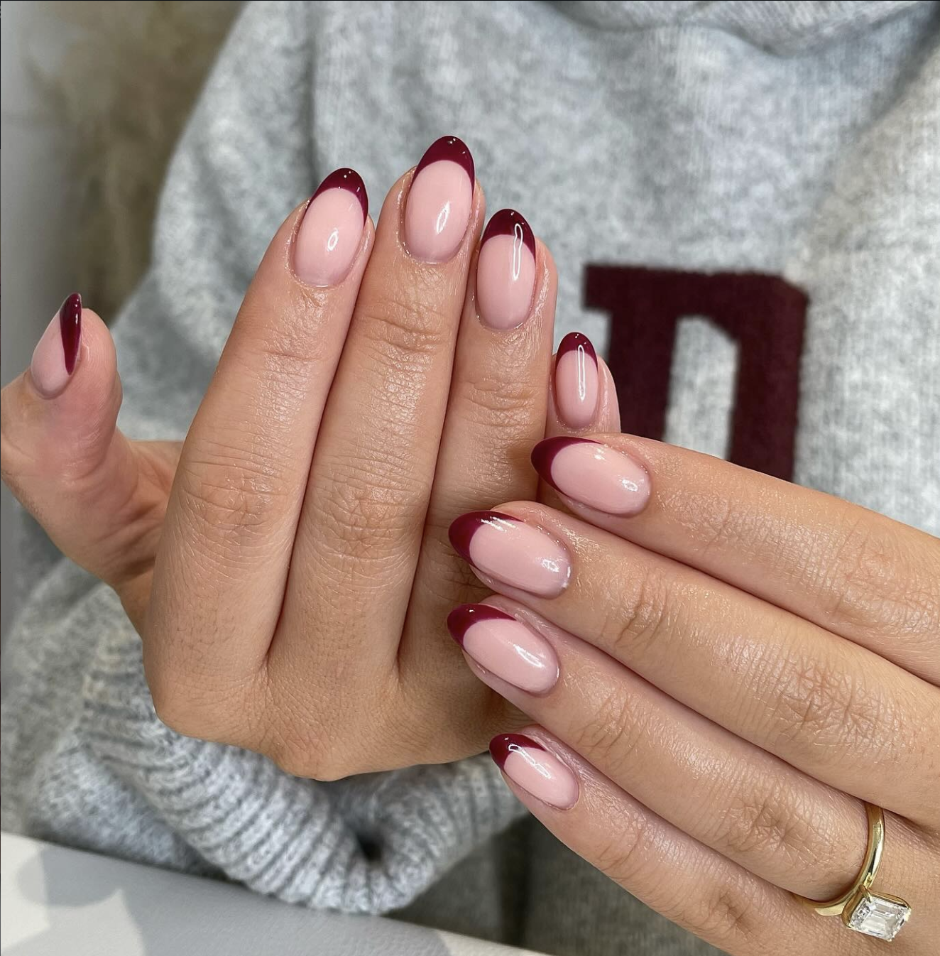 Short nails with alternating burgundy and brown micro-French tips.