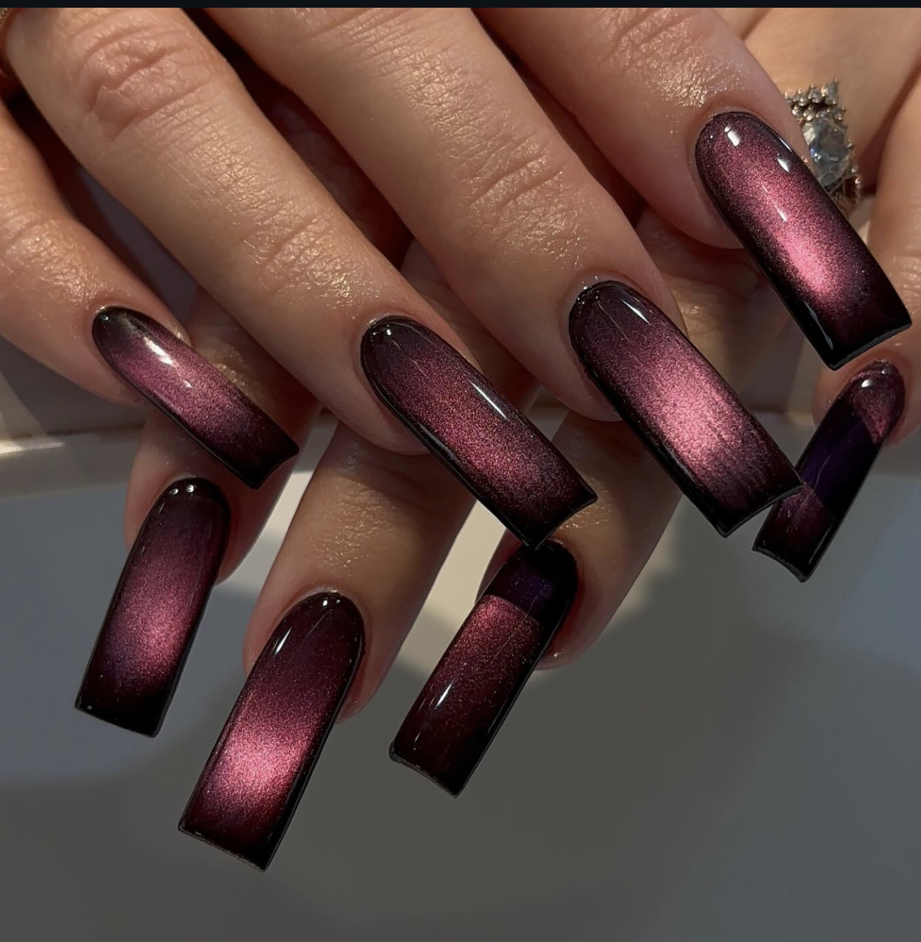 Moody brown velvet cat-eye manicure with a soft magnetic glow.