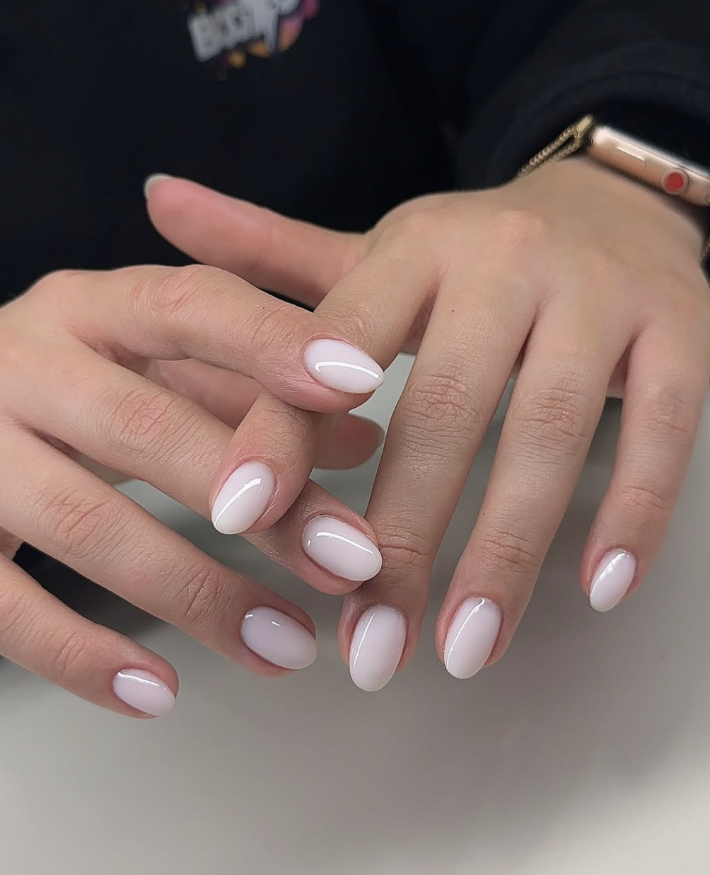 Long almond shaped nails with a semi-sheer milky white gel polish and a high-gloss finish.