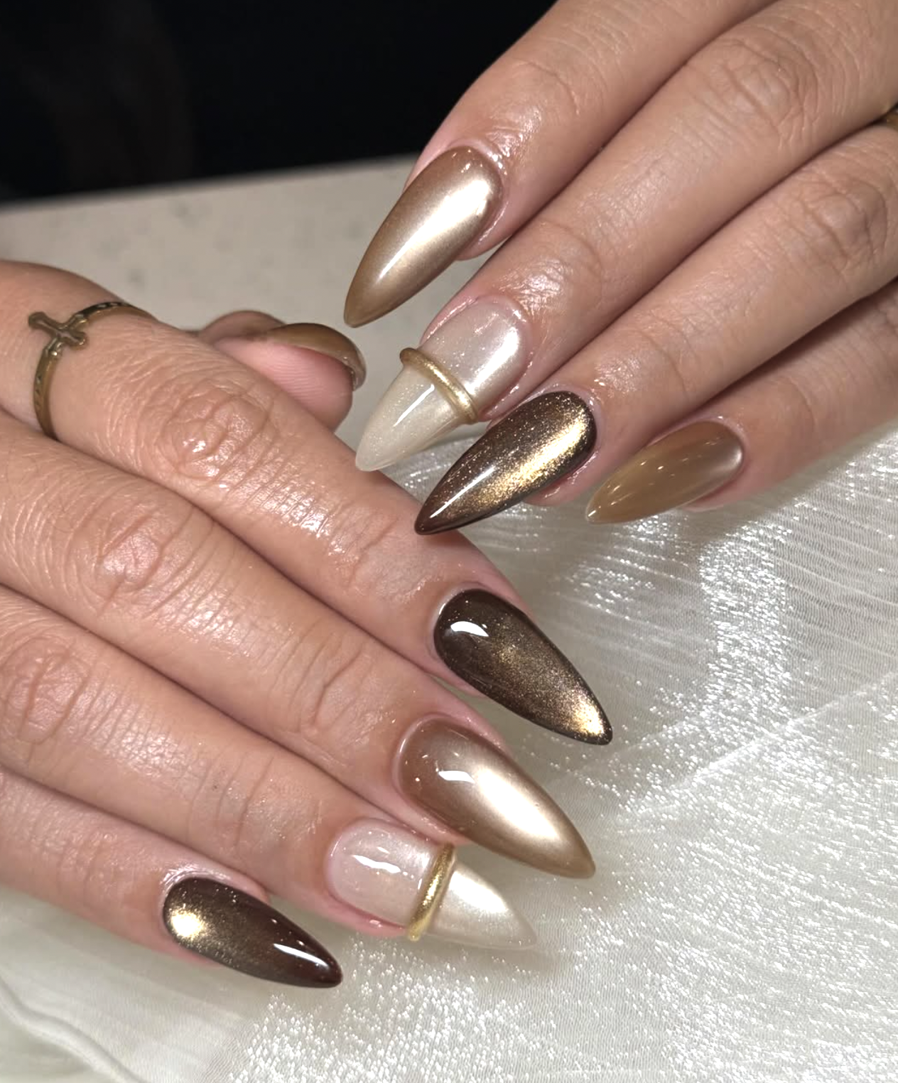 Soft champagne shimmer polish on short almond-shaped nails